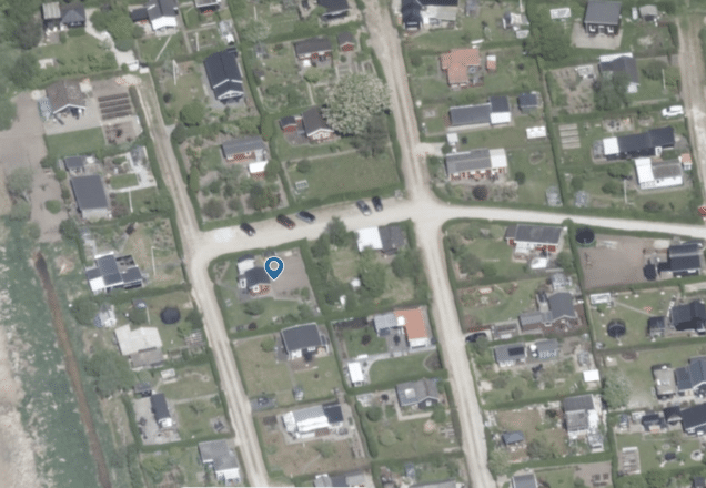 Luftfoto af kolonihaver i Randers NV med grønne områder og små huse.