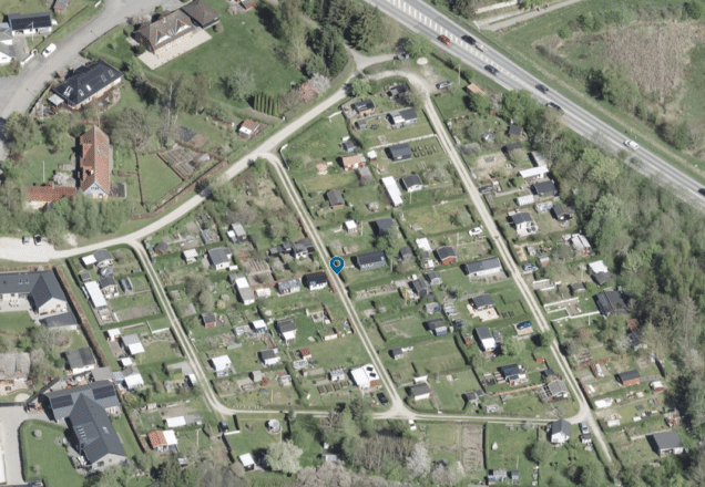 Aerial view of a koloniområde with small allotment plots and green spaces.